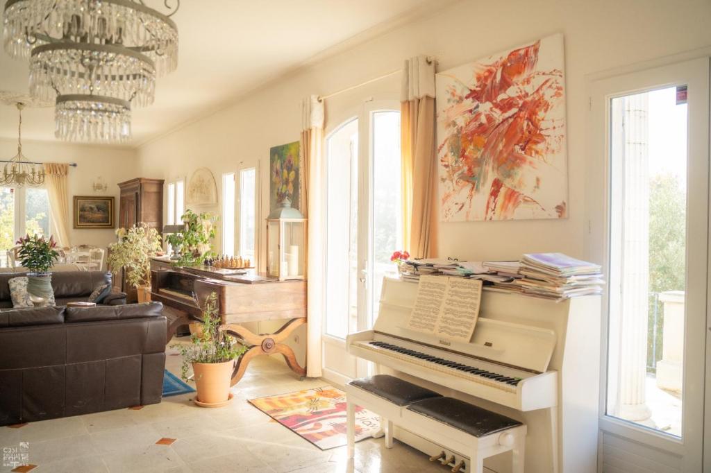 a living room with a piano and a couch at Bastide de Valvérane in Manosque