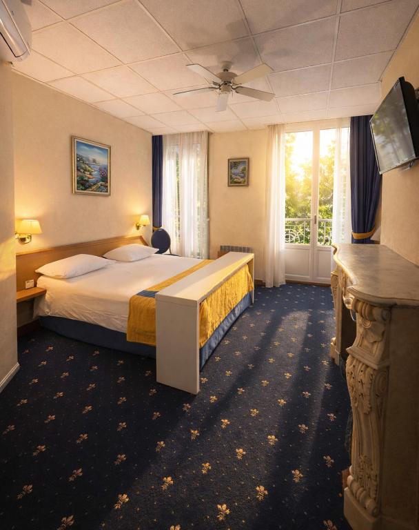 una camera d'albergo con un letto e una finestra di Hôtel Foch a Lione
