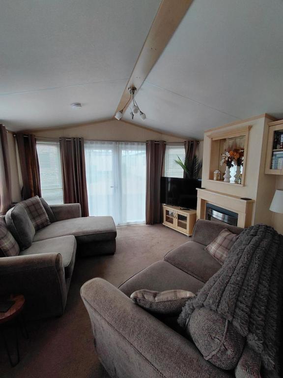 a living room with two couches and a tv at Holiday Home in Forfar