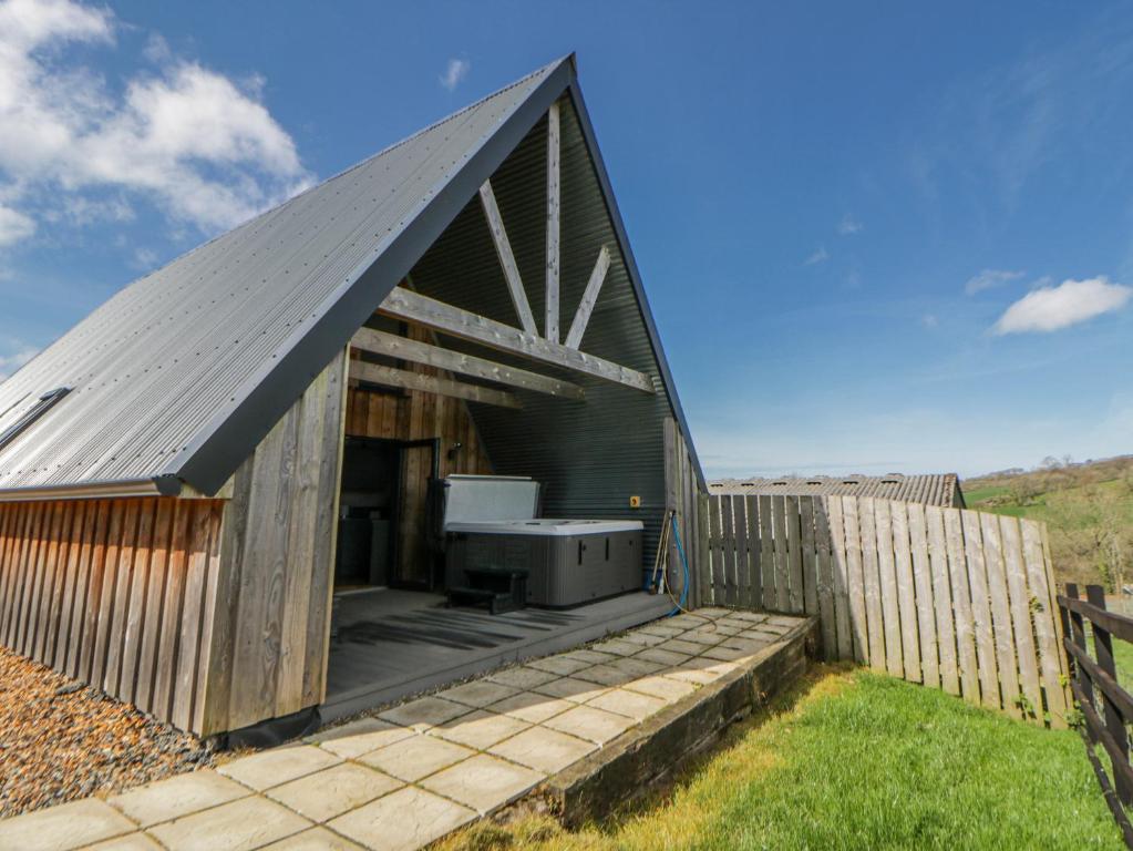a small black building with a grill on a deck at Valley View Hideaway in Llandysul