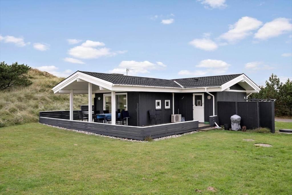 a small black house with a large backyard at VE494-Orbaek-Jafdalvej-51 in Ørbæk