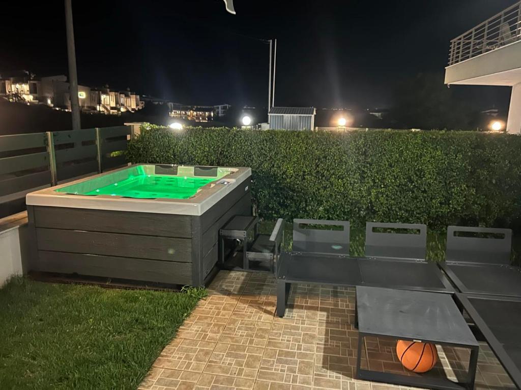 a backyard with a pool and ping pong table at Coral Nikiti Apartments I in Nikiti