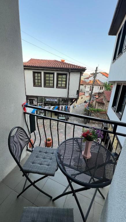 a balcony with a table and chairs and a house at Apartmani Marija in Ohrid