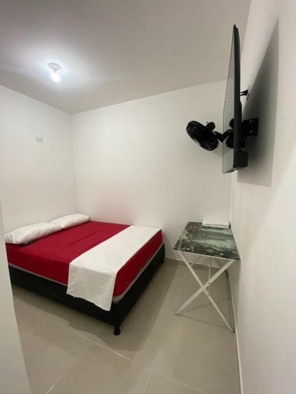 a bedroom with a red and white bed and a table at Apartamento Tercer Cielo 202 in Cúcuta