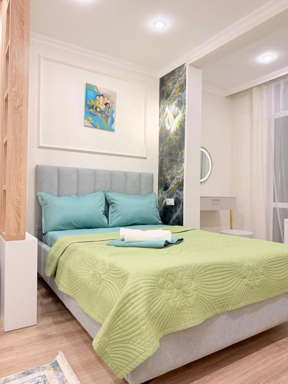 a bedroom with a large bed with a green blanket at Ulytau in Almaty