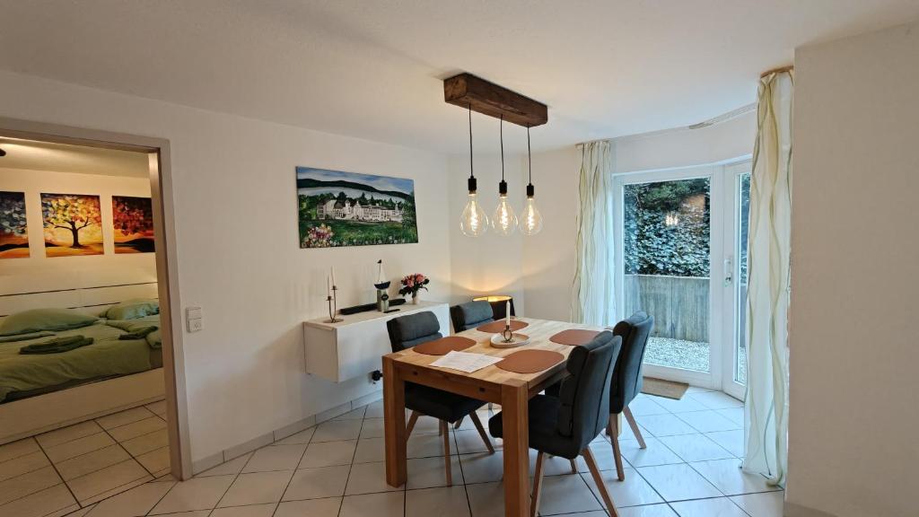a dining room with a table and chairs and a bedroom at Ferienwohnung Waldblick in Allensbach