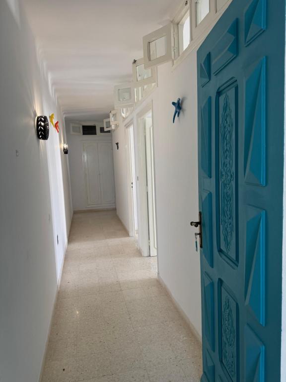 a hallway with a blue door in a room at Résidence central 1 in Nabeul