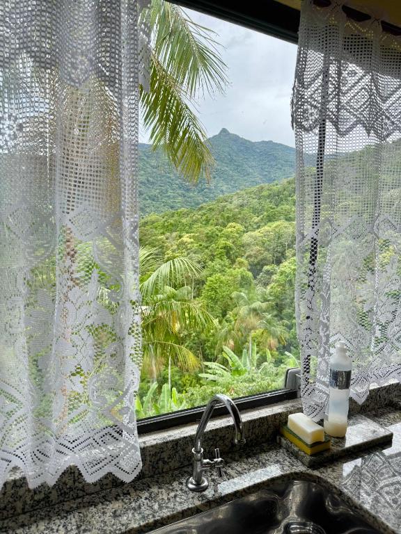 a window with a sink and a view of a mountain at Loft com vista Panoramica in Paraty