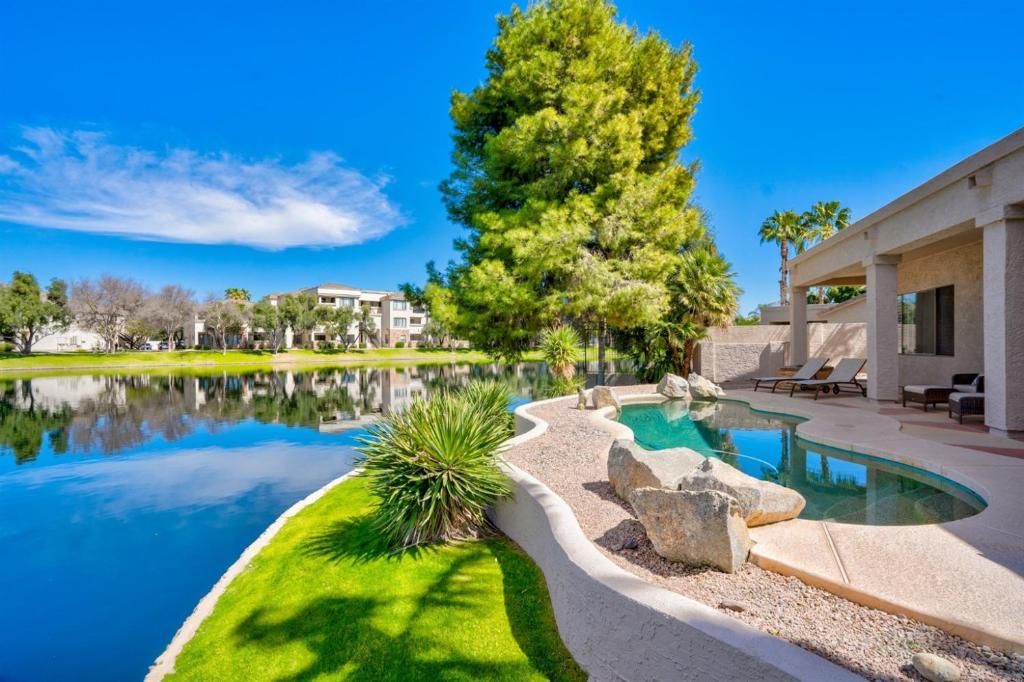 a swimming pool in a yard next to a lake at Gorgeous Lakefront Paradise w Pool & Views in Chandler