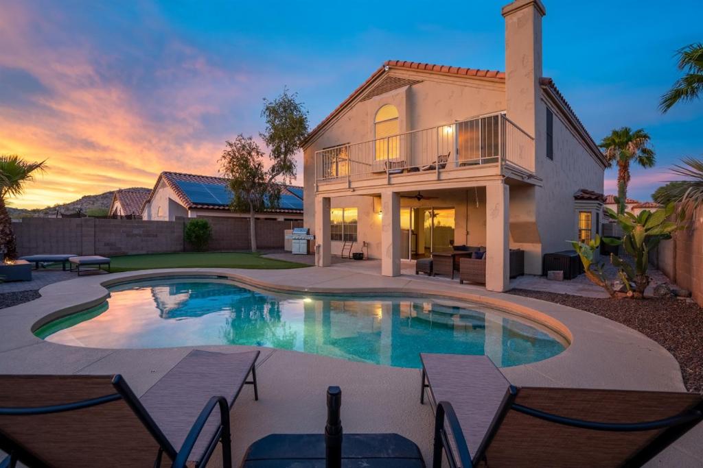 a house with a swimming pool in front of a house at Heated Pool 3BR Retreat Estrella Mountain in Goodyear
