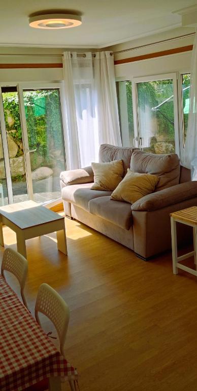 a living room with a couch and a table at EnFOZ Terraza XXL Pet Friendly in Foz