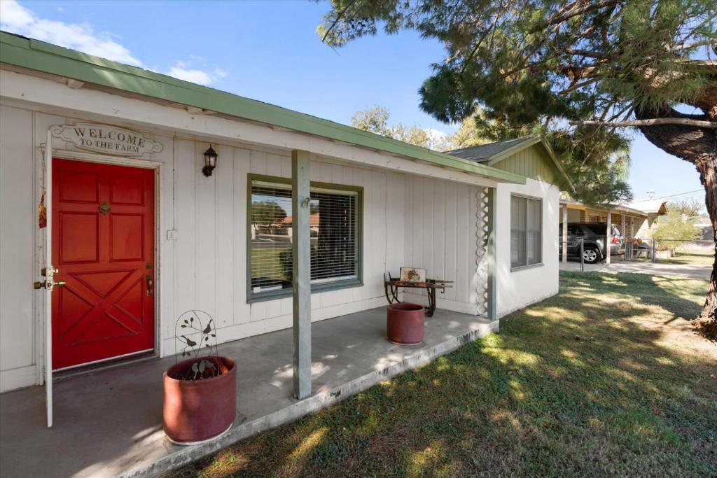 a white house with a red door and a yard at Charming 2-BR Farmhouse Backyard Views in Mesa