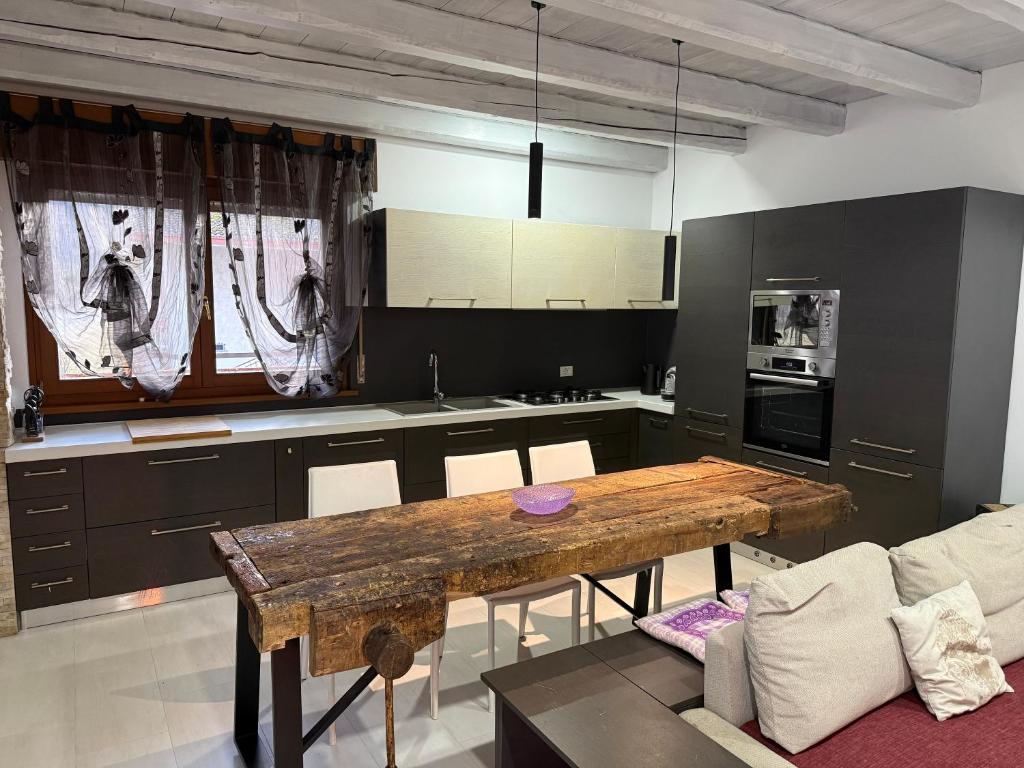 a kitchen with a wooden table in a room at Casa Lalli in Longarone