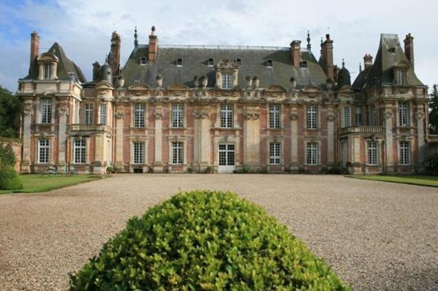 un gran edificio con un seto delante de él en Château de Miromesnil, en Tourville-sur-Arques