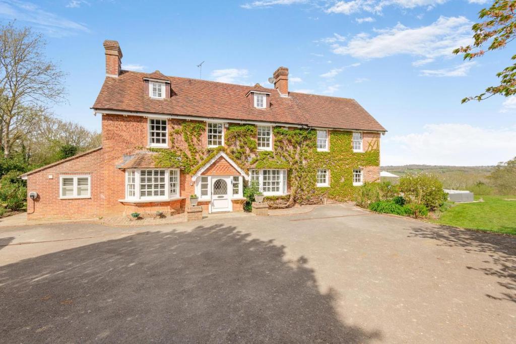 a large brick house with a driveway at 6 Bed in Hadlow Down oc-g36329 in Hadlow Down