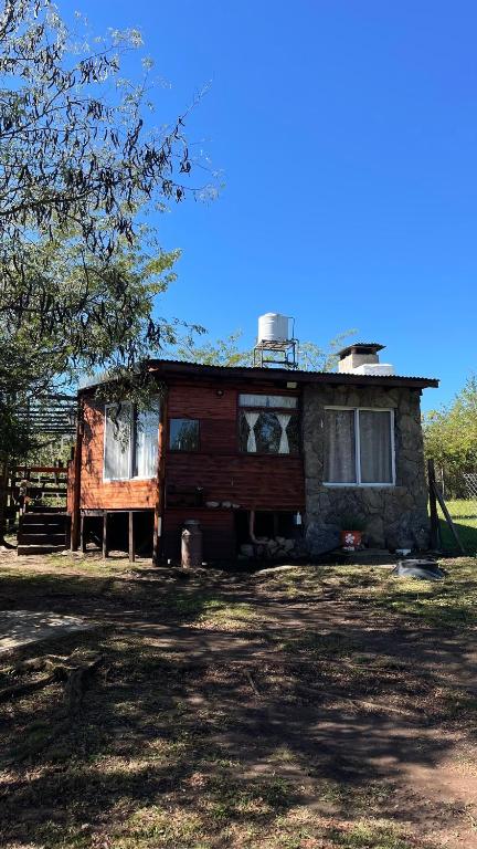 a house that is sitting in the grass at Hospedaje Lourdes in Villa Yacanto