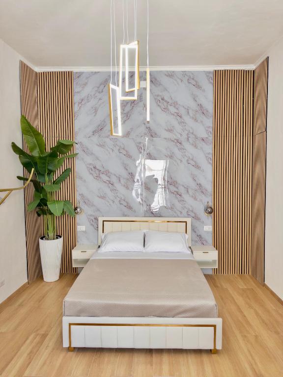 a bedroom with a bed and a wall at Onny's Palace in Bari