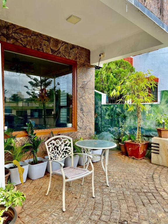 a patio with a table and chairs and plants at Nirvana Yogashala Retreat in Mysore