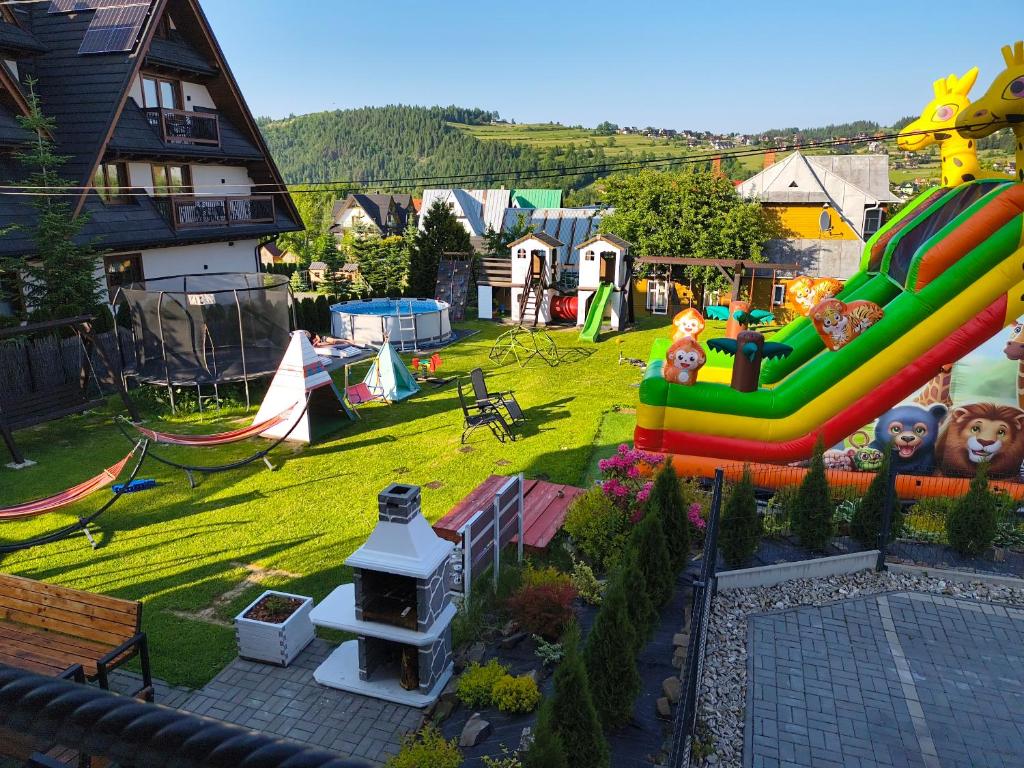 a backyard with a playground with a inflatable slide at Willa Harnikówka in Białka Tatrzańska