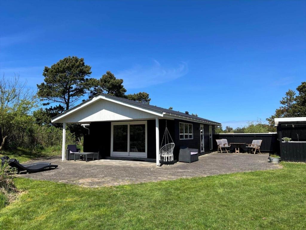 a black house with a porch and a patio at VE160-Vejers-Strand-Engesovej-69 in Vejers Strand