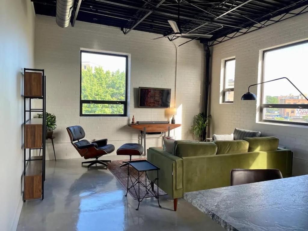 a living room with a green couch and chairs at Classic Pied a Terre in Benton Harbor