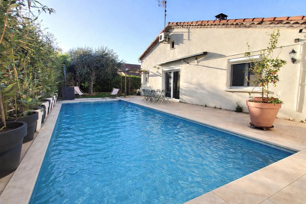 a swimming pool in front of a house at VILLA EN PROVENCE AVEC PISCINE AU CALME À ARLES - Camargue in Arles