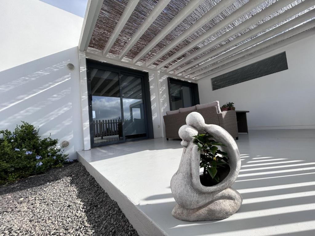 a house with a statue of a plant on a patio at Bio Home La Asomada in Tías