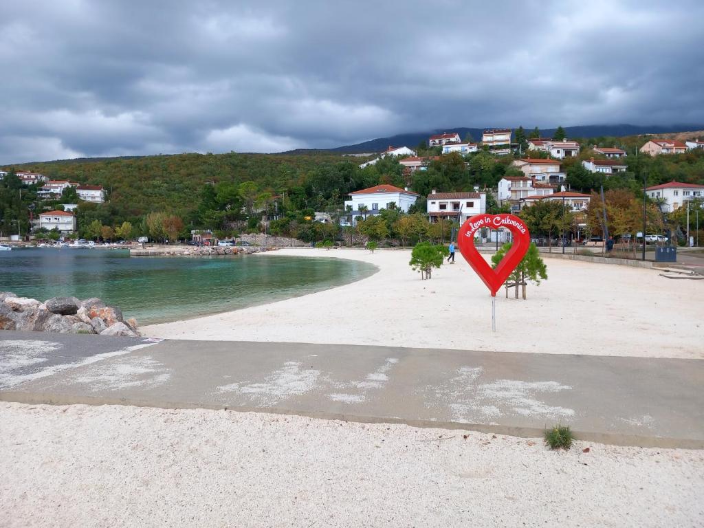 a beach with a heart sign on the sand at Apartma Dana in Jadranovo