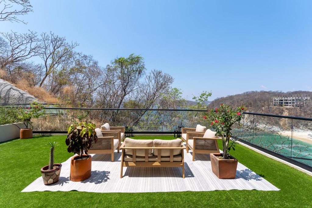 a patio with chairs and plants on a balcony at 3101 - Paradise Cove 1A Violin in Tangolunda