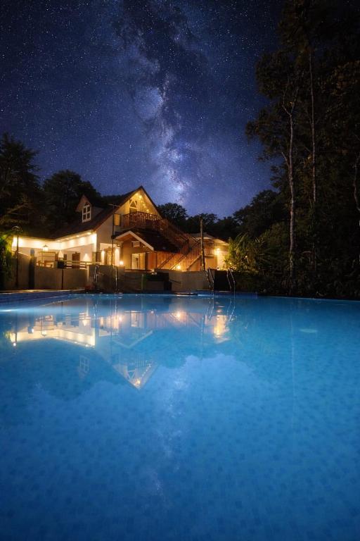 a house at night with a swimming pool at Cloud Hills Munnar in Kallar Vattiyar