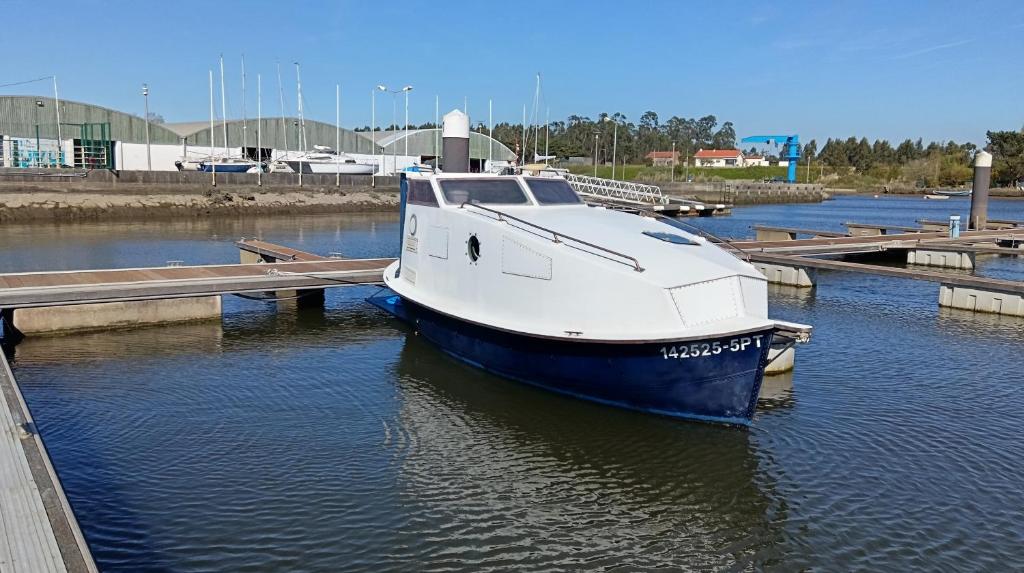 a blue and white boat docked at a dock at The Boat in Ovar