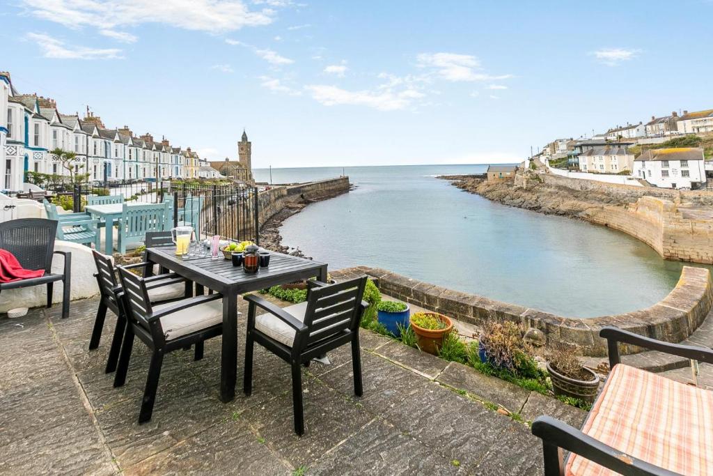 a table and chairs on a patio overlooking the water at 3 Bed in Porthleven oc-harbli in Porthleven