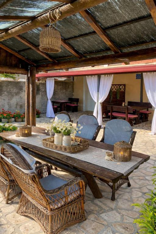 a wooden table and chairs under a patio umbrella at Apartmani AJP Posedarje in Posedarje