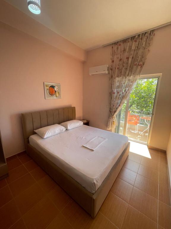 a bedroom with a bed and a large window at Bleta Residence in Sarandë