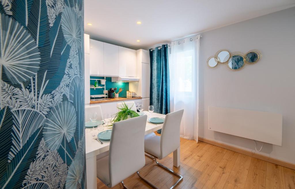 a kitchen and dining room with a table and chairs at Appartement la Perle in Ambérieu-en-Bugey