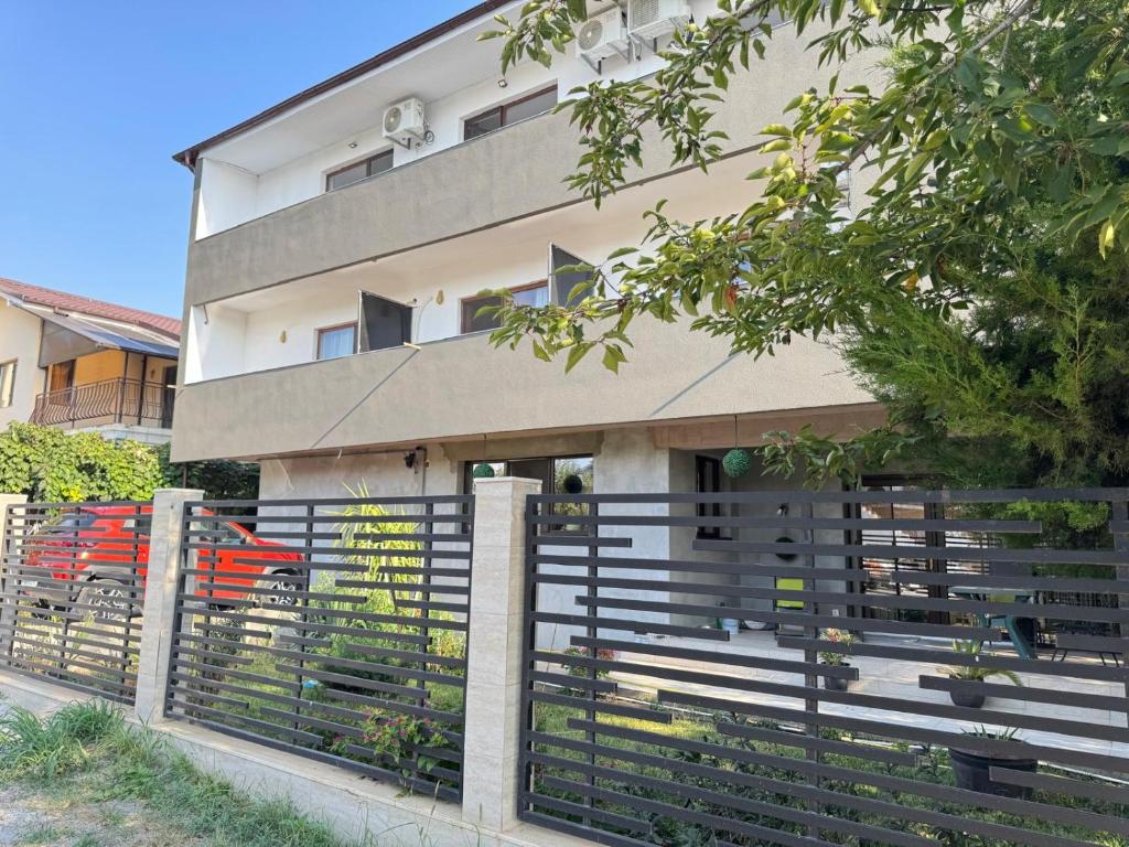 a building with a fence in front of it at Vila Ana Trident Costinesti in Costinesti