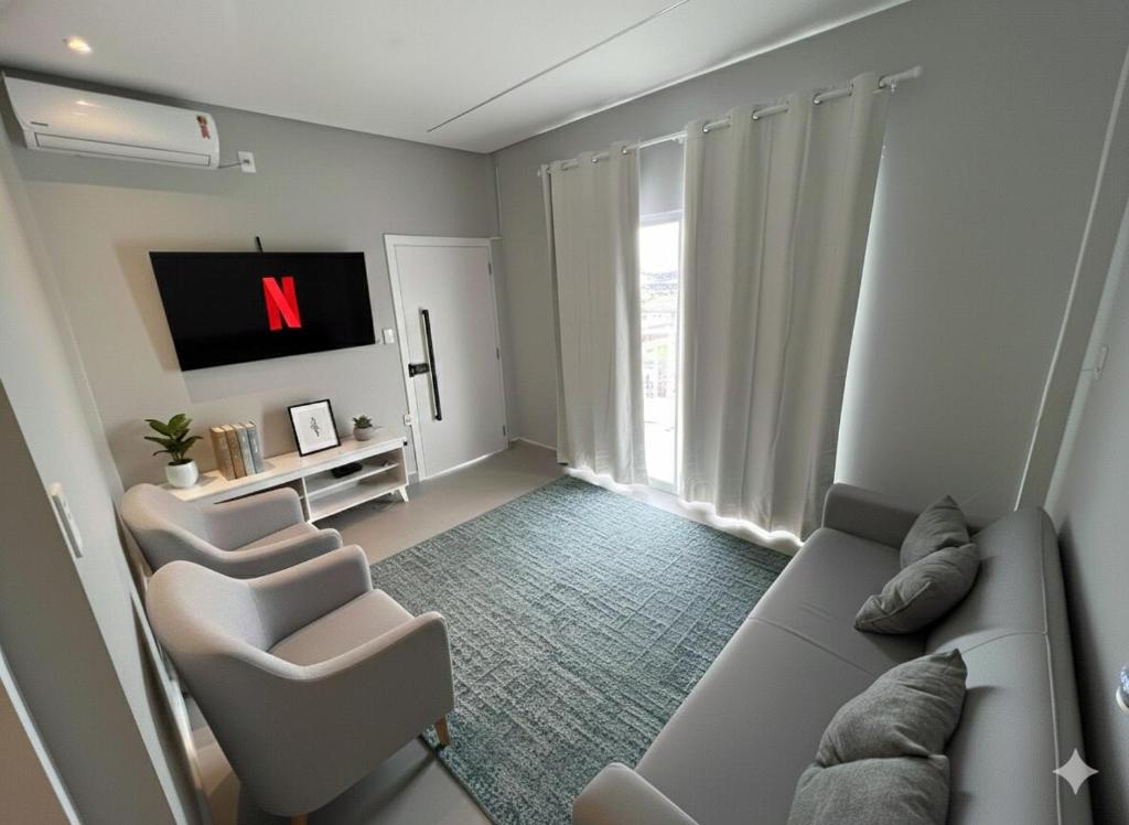 a living room with a couch and chairs and a tv at Modern apartment, with excellent location in Macapá
