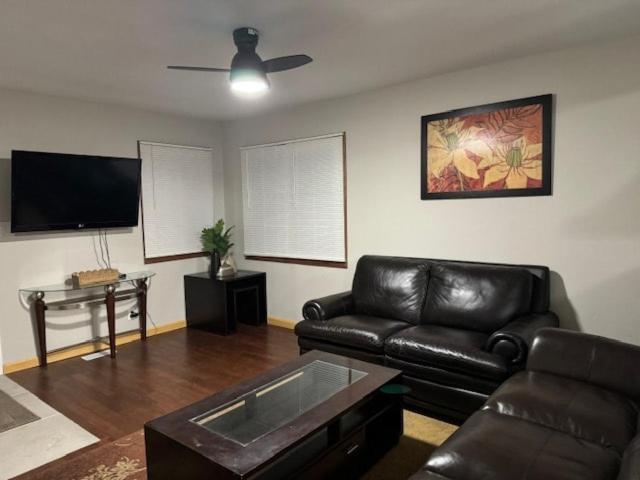 a living room with a leather couch and a tv at Sunnyside Rental-Entire vacation home 3 Bedroom 2 Bathrooms 1 Kitchen in McHenry