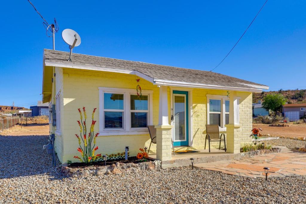 a small yellow tiny house with a satellite at Route 66 Roadtripper Retreat w/ Private Backyard in Kingman