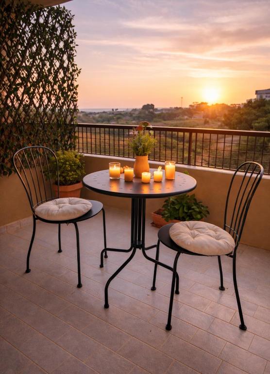 a table and two chairs with candles on a balcony at Vista Mare 22 Due Camere triple o doppie in Bari