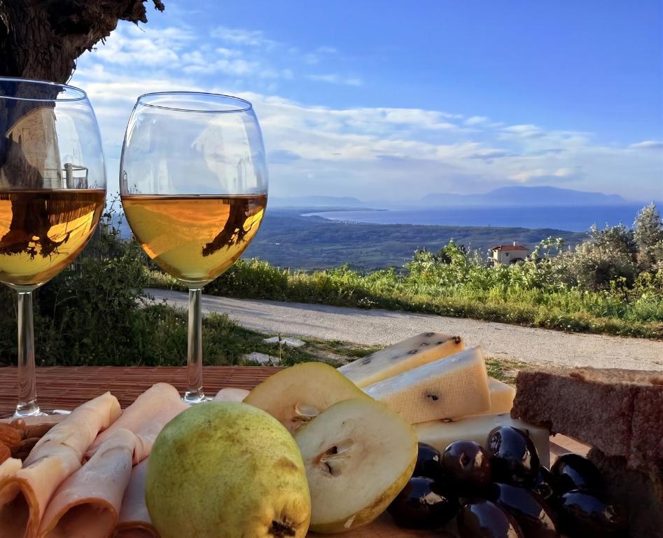 a table with two glasses of wine and cheese at Camarina Sea View in Kamarína