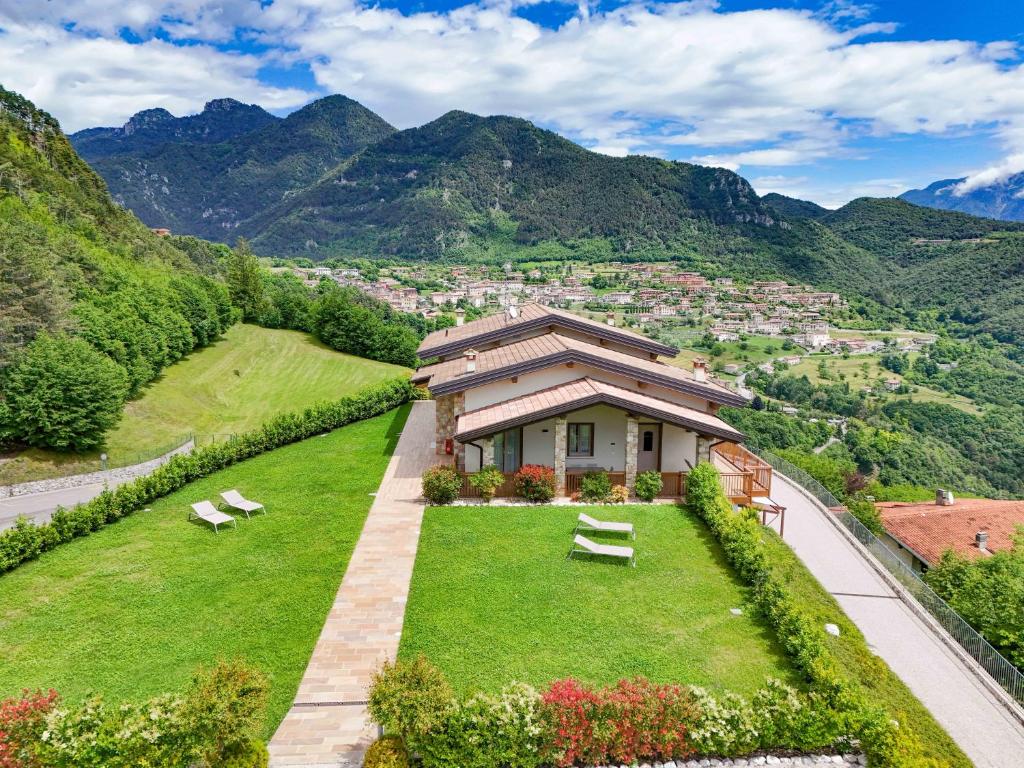 a house on a hill with mountains in the background at Agriturismo Hegemone in Tremosine Sul Garda
