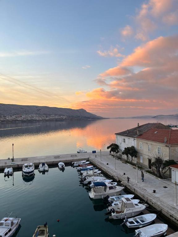 a group of boats docked in a marina at sunset at Laguna Apartments in Pag
