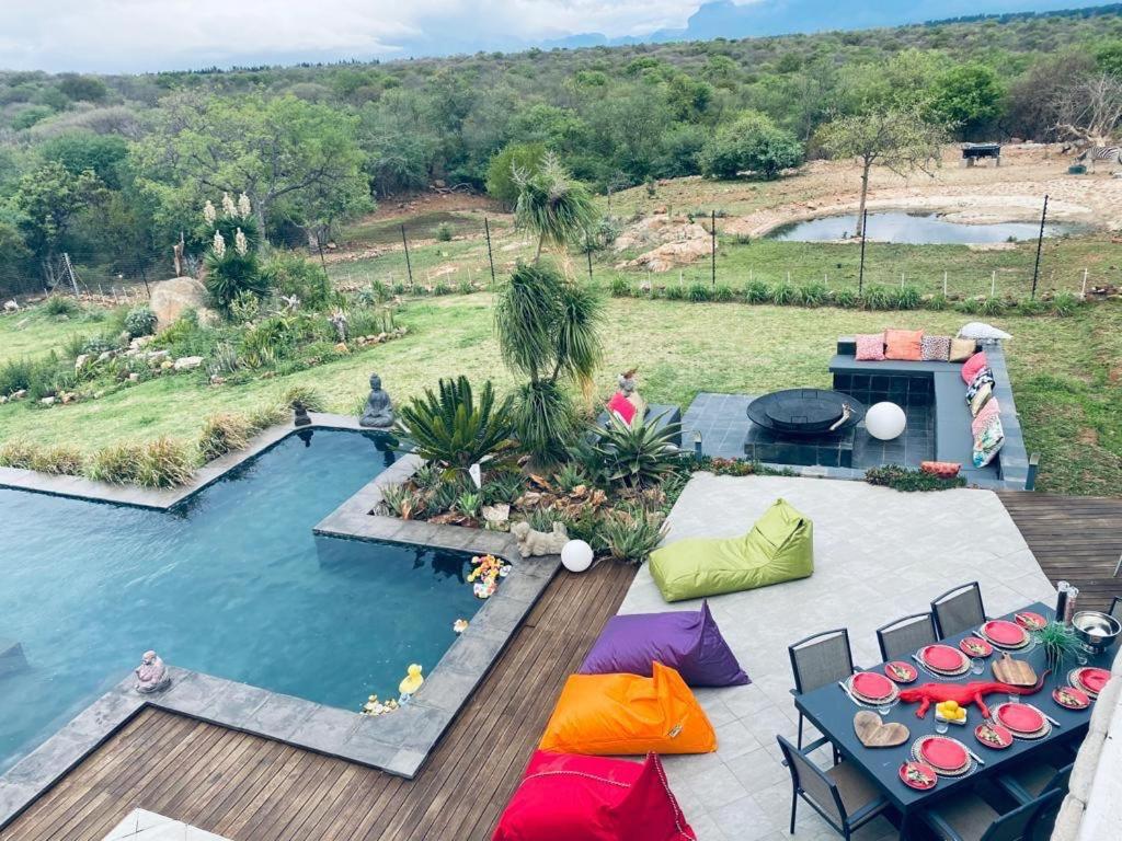 an overhead view of a pool with tables and chairs at hippomoon lodge game reserve in Hoedspruit