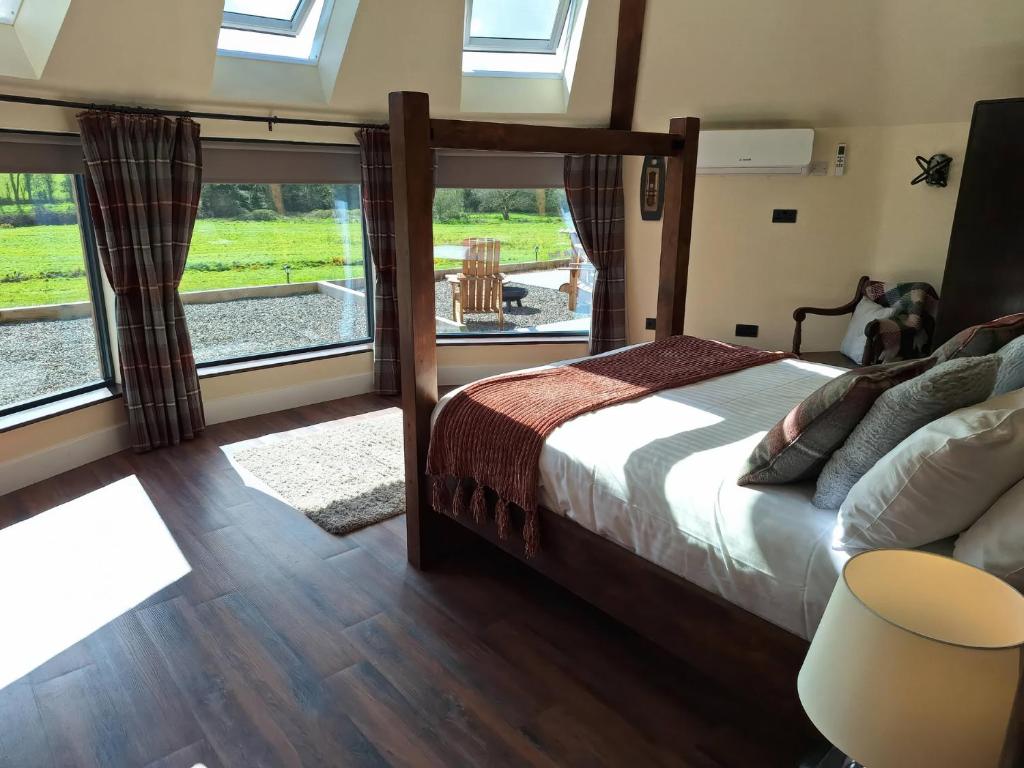 a bedroom with a bed and a large window at Y Cwlwm - The Celtic Knot in Lampeter