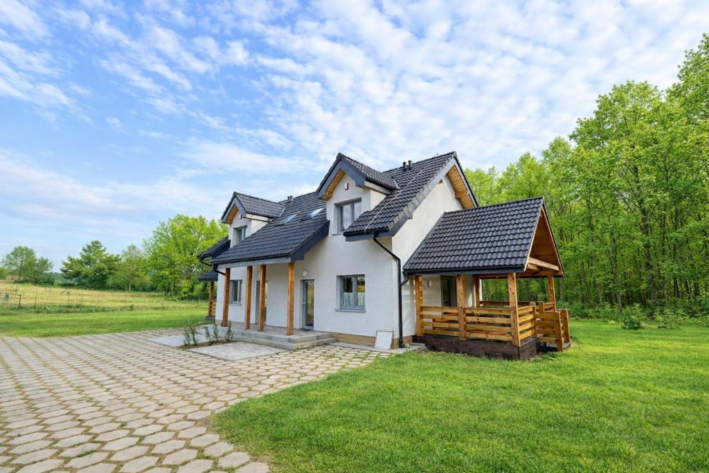 a house with a gambrel roof on a field at Lisia Górka in Debina