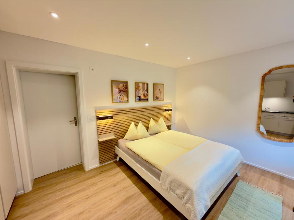 a bedroom with a large bed and a mirror at Hirsere Studio 2 in Ursenbach