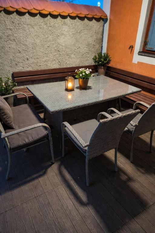 a table and chairs with a candle on a patio at Apartma Dian in Mostec