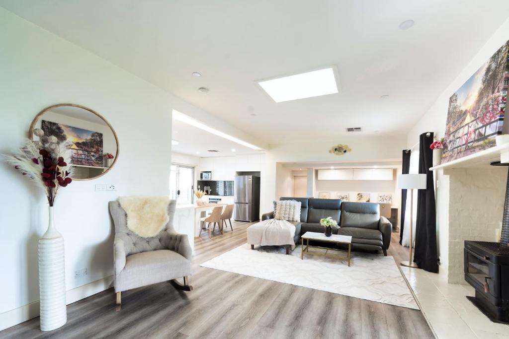 a living room with a couch and a chair at 5BR - The Boulevarde Miranda - Parking in Miranda