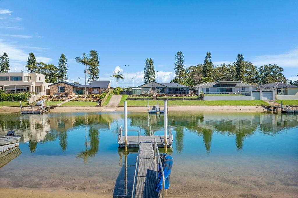 a dock in a body of water with houses at Francis 31 in Port Macquarie